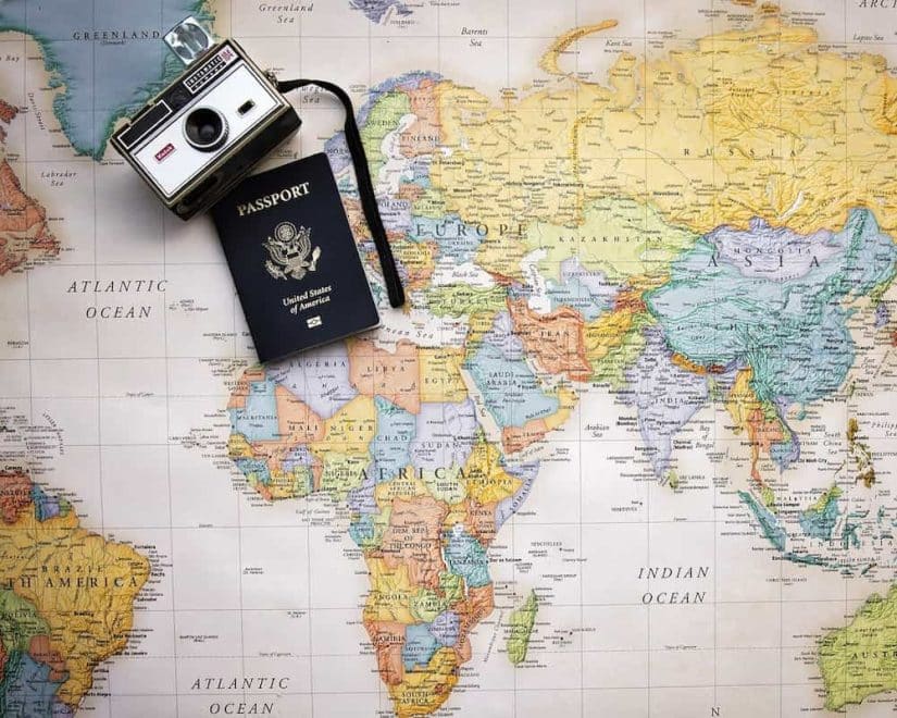mapa com um passaporte e uma câmera em cima 