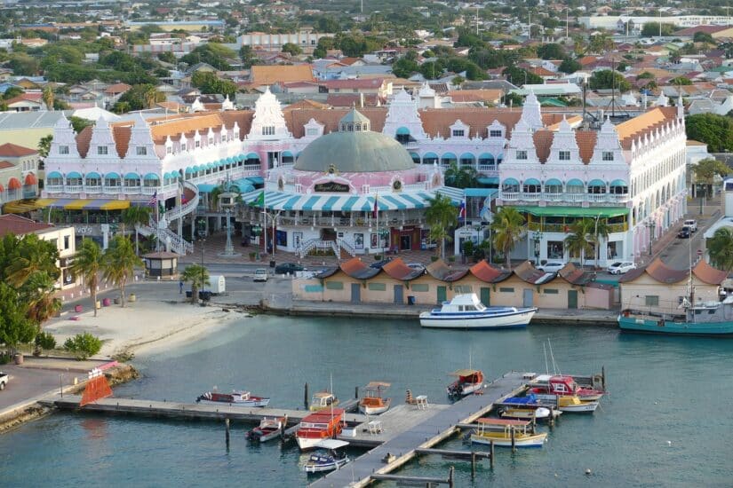 Edifícios coloridos em estilo colonial holandês à beira-mar, perfeitos para sua viagem com seguro viagem para Aruba.