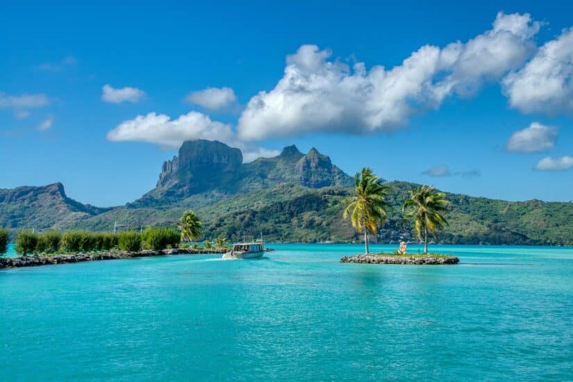 Água turquesa e palmeiras aguardam - explore a exuberante Bora Bora com tranquilidade usando seguro viagem para Bora Bora.