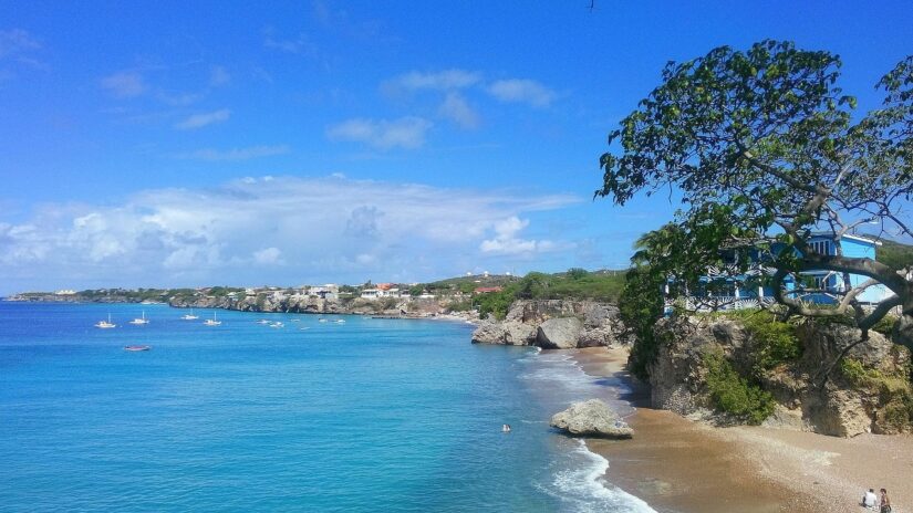 Mar azul claro e praia de areia em Curaçao — não se esqueça do seu seguro viagem para Curaçao para uma viagem sem preocupações!.
