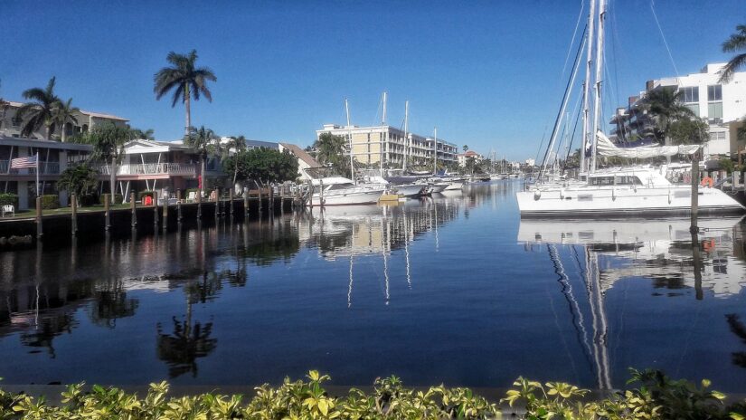 Barcos atracados ao longo de um canal calmo na Flórida, cercado por palmeiras — ideal para quem tem seguro viagem para Flórida.