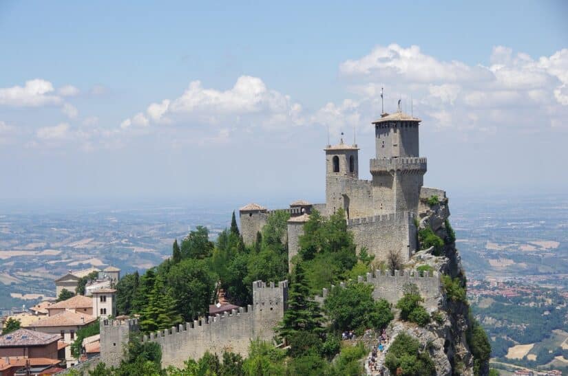 Fortaleza medieval de pedra com torres no topo de uma colina, perfeita para explorar com seguro viagem para San Marino.