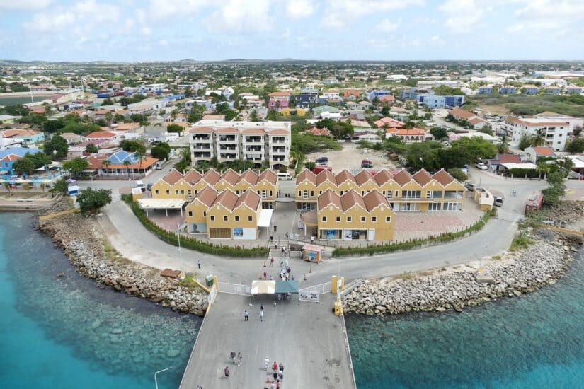 Vista aérea de uma cidade costeira em Bonaire com casas coloridas — não se esqueça do seu seguro viagem para Bonaire!.