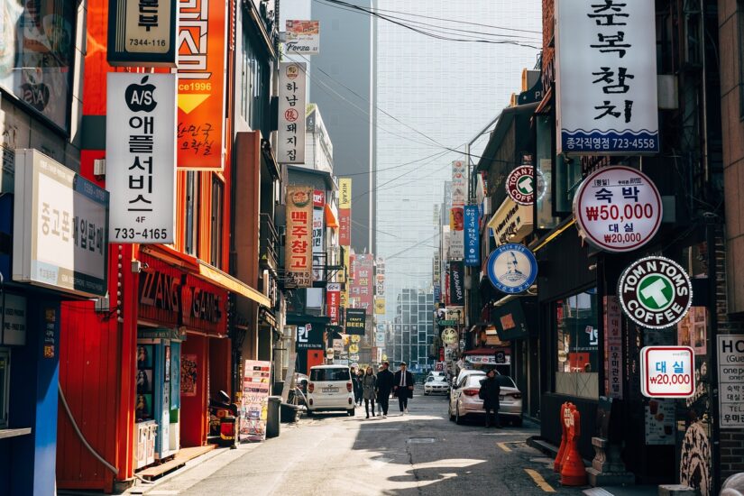 Uma movimentada rua urbana na Coreia do Sul, repleta de prédios altos e placas coloridas, repleta de usuários de eSIM.