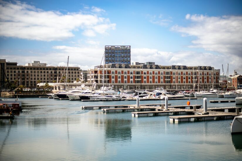 Waterfront é um dos Melhores bairros para turistas na Cidade do Cabo na África do Sul Iates atracados em uma marina com edifícios modernos - descubra onde ficar em Cape Town em meio a vistas panorâmicas e céus nublados.