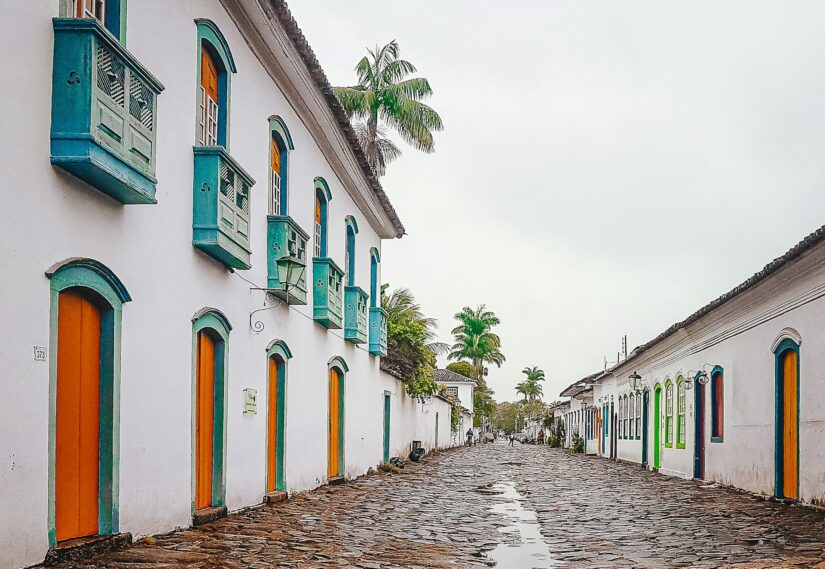 melhores hotéis no centro histórico de parati Rua de paralelepípedos ladeada por edifícios coloniais coloridos em Paraty - descubra onde ficar em Paraty sob um céu nublado.
