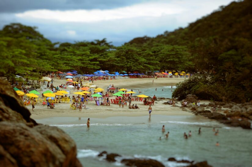 melhores hotéis e pousadas em Trindade no Rio de Janeiro Praia lotada de Trindade com guarda-sóis coloridos em Paraty, pessoas nadando, relaxando - perfeito para dicas sobre onde ficar em Paraty.