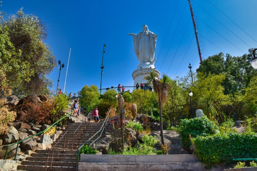 Hotel bem localizado no Chile perto do cerro san cristóbal As pessoas sobem as escadas em direção a uma grande estátua branca da Virgem Maria no Cerro San Cristóbal, uma visita obrigatória para os visitantes que buscam onde ficar em Santiago.