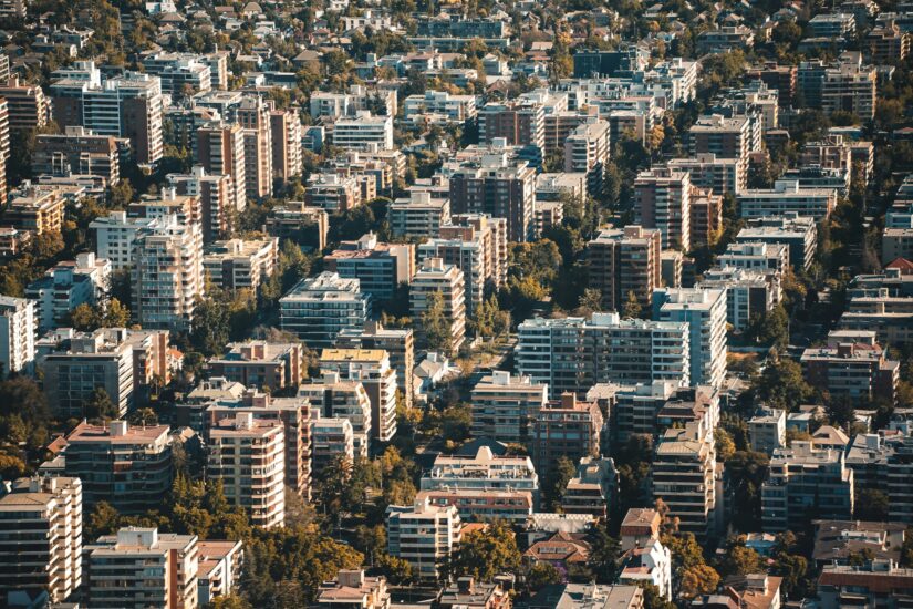 onde ficar em Santiago no bairro recoleta no chile Vista aérea de da capital do Chile, com muitos prédios de apartamentos de médio porte cercados por árvores.