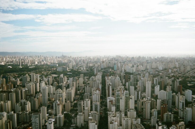 onde ficar em São Paulo em Moema perto de Congonhas Vista aérea de Moema, uma paisagem urbana extensa com muitos edifícios altos sob um céu parcialmente nublado.