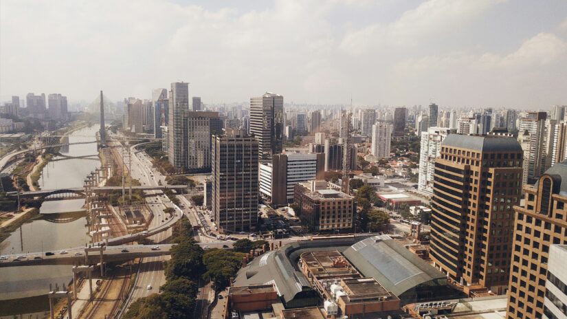 onde ficar em São Paulo na Vila Olimpia Vista aérea de SP, mostrando edifícios altos da Vila Olímpia, estradas e um rio que serpenteia pela área urbana.
