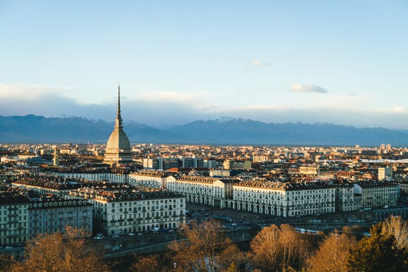 melhores hotéis em san salvario valentino em torino na itália Paisagem urbana de Turim, Itália, onde ficar em Turim, com a Mole Antonelliana e montanhas sob um céu claro.