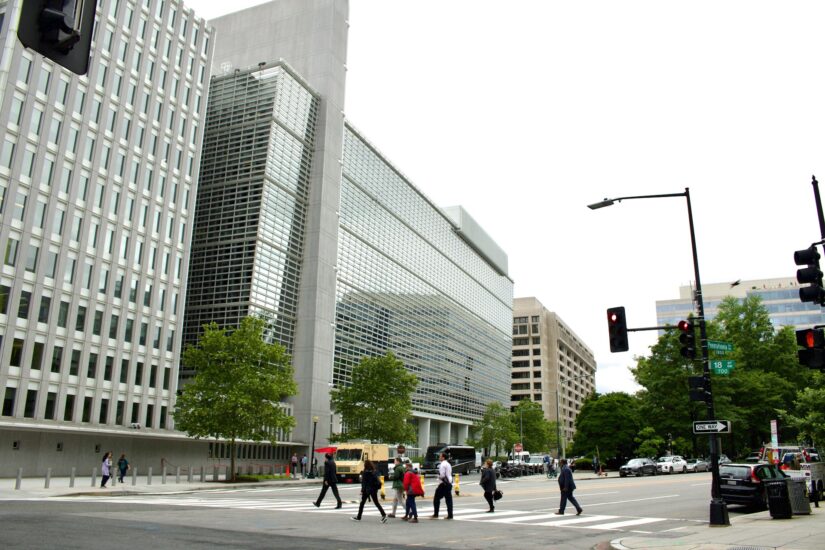 Pessoas atravessando uma rua perto de um grande e moderno prédio de escritórios - ótima cena para onde ficar em Washington.