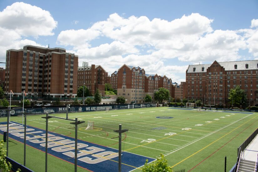 Campo de lacrosse na Universidade de Georgetown, um dos principais locais para onde ficar em Washington, emoldurado por dormitórios de tijolos e nuvens.