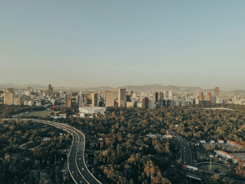 hotéis em Juarez no México Vista aérea de onde ficar na Cidade do México: horizonte da cidade, rodovias, prédios altos e um grande parque verde.