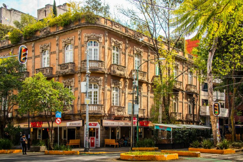 hotéis em Condesa no México Um edifício histórico e ornamentado com varandas e vegetação no telhado - um local ideal onde ficar na Cidade do México.