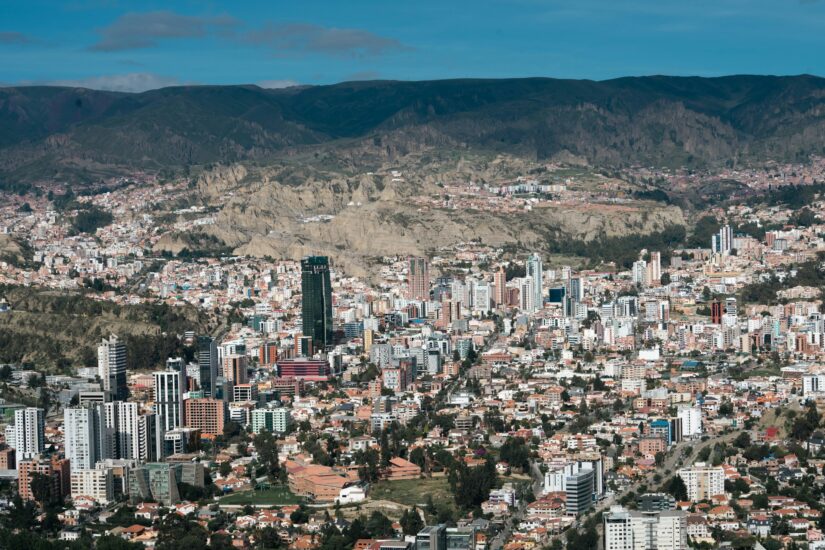 onde ficar em La Paz no bairro Calacoto Vista aérea de da capital da Bolívia mostrando Calacoto, edifícios da cidade aninhados entre montanhas sob um céu parcialmente nublado.