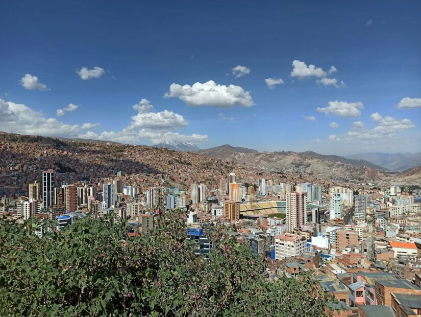 Melhor bairro de La Paz Sopocachi Uma paisagem urbana com prédios altos, montanhas e arbustos sob um céu azul - perfeita para descobrir onde ficar em La Paz em Sopocachi.