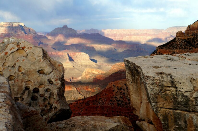 melhores hotéis em Tusayan no Arizona A luz do sol e as sombras destacam as camadas de rochas coloridas em Tusayan, onde você pode refletir sobre onde ficar no Grand Canyon entre duas formações.