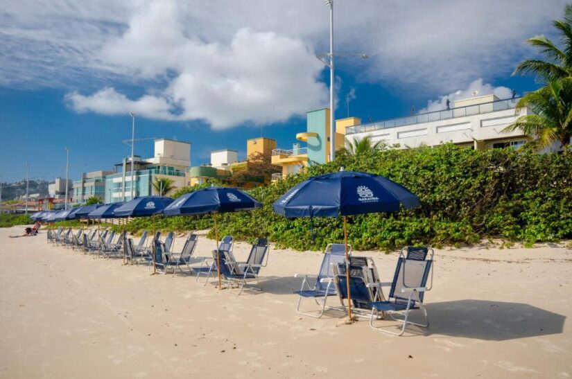 onde ficar em Bombinhas na Praia de Bombas Cadeiras de praia vazias e guarda-sóis azuis se alinham na Praia de Bombas em Santa Catarina.