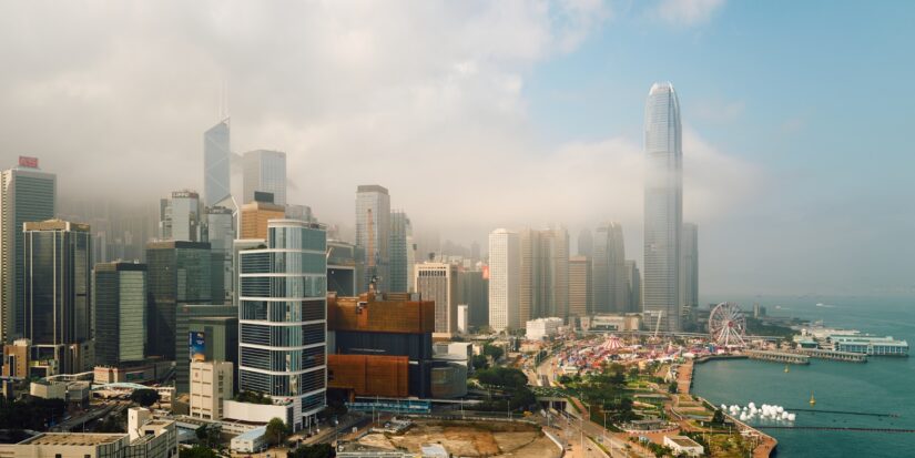 onde ficar em Hong Kong em Wan Chai Horizonte de Wan Chai com arranha-céus altos, neblina e um porto em um dia parcialmente nublado.
