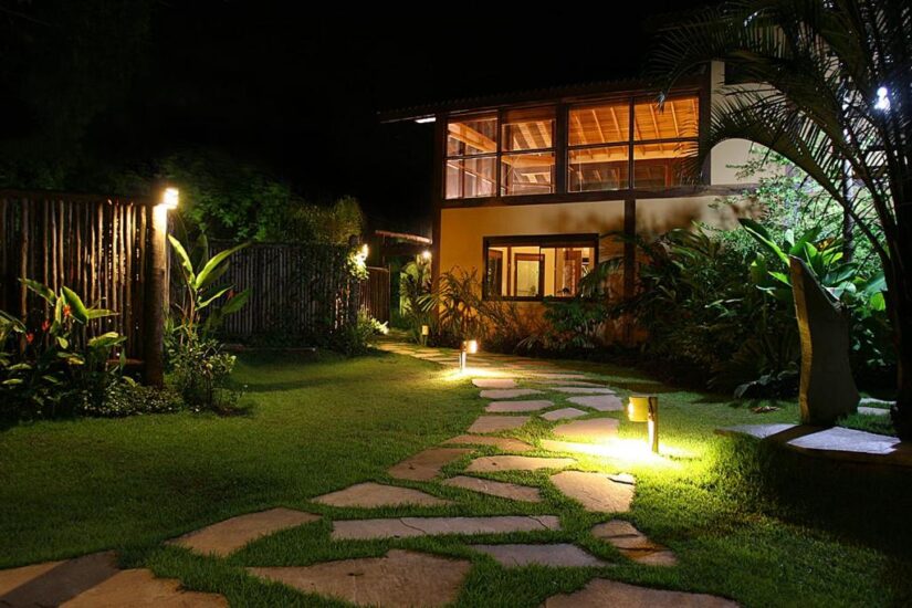 hotéis e pousadas perto da Barra do Sahy O caminho de pedra e o jardim iluminado por luzes quentes levam a uma casa moderna - ideal se você estiver procurando onde ficar em Barra do Una à noite.