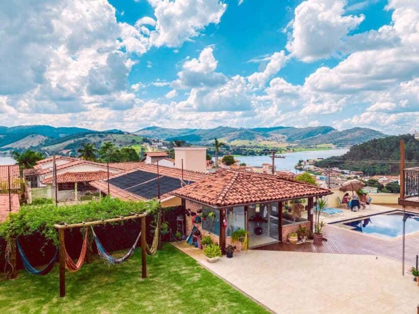 pousadas no interior de Minas Gerais Pátio ensolarado com redes, uma piscina e colinas panorâmicas - perfeito para onde ficar em Capitólio à beira do lago sob o céu azul.