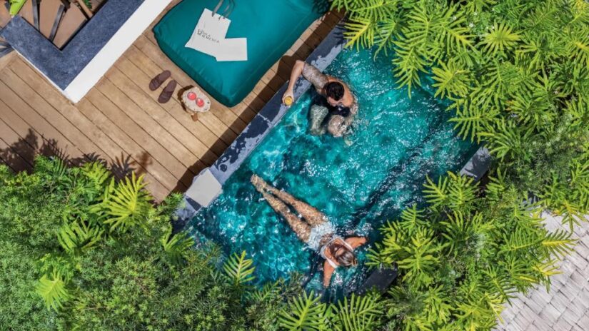 onde ficar em Caraíva no Meio da Vila na Bahia Um casal relaxa em uma pequena piscina cercada por uma vegetação exuberante - um local ideal para relaxar perto de Porto Seguro na Bahia.
