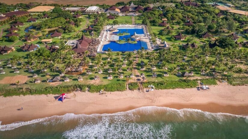 hotel resort Vila Galé Marés na Bahia Vista aérea de onde ficar em Guarajuba: um resort de praia Vila Galé Marés com piscina, palmeiras e espreguiçadeiras na areia da praia.