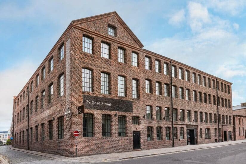 Um grande edifício onde ficar em Liverpool de tijolos de três andares em uma esquina, com muitas janelas e uma placa indicando 29 Seel Street.