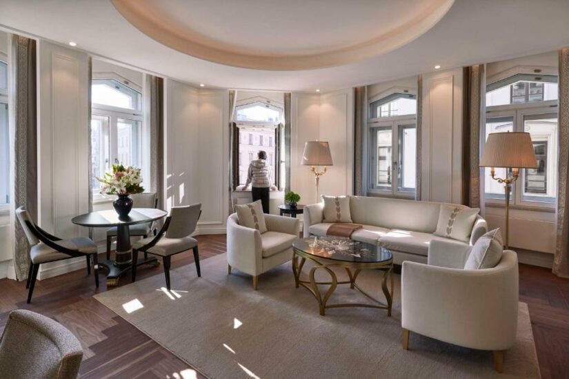 Sala de estar elegante com móveis creme, janelas grandes e uma pessoa em pé em uma janela aberta onde ficar em Munique