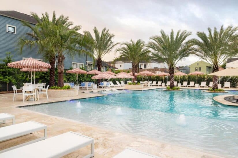 onde ficar em Nova Orleans no Garden District Uma piscina em uma área residencial do Garden District com espreguiçadeiras brancas - perfeita para relaxar e planejar sua estadia no Garden District Hotel nos Estados Unidos.