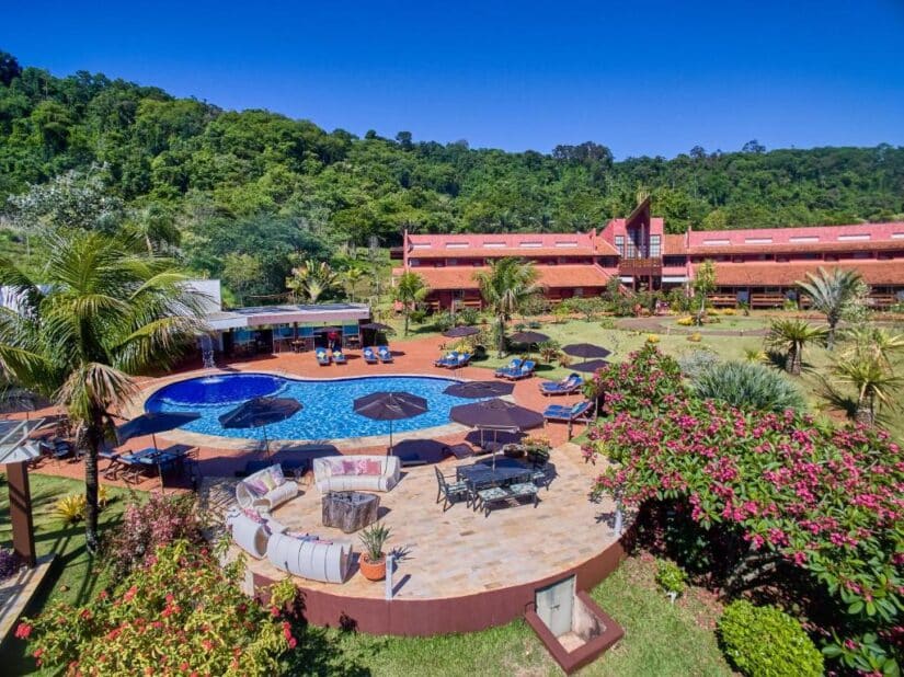 onde ficar em Brotas na Região da Cachoeiras Um resort com piscina, espreguiçadeiras e palmeiras - perfeito para quem procura resorts no interior de São Paulo para ecoturismo, cercado por colinas exuberantes.