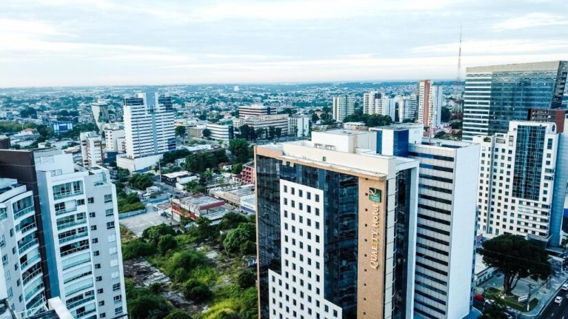 melhores hotéis em Adrianópolis e Vieiralves no Amazonas Vista aérea de onde ficar em Manaus em Adrianópolis ou Vieiralves: paisagem urbana com prédios altos e modernos e vegetação sob um céu nublado.