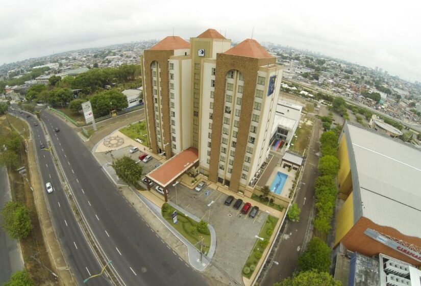 onde ficar em Manaus em Japiim Vista aérea de um hotel alto com piscina, cercado por estradas, carros e vegetação em Japiim no Amazonas.