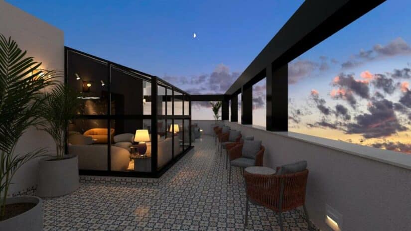 Lounge moderno na cobertura Onde ficar em Tel Aviv ao pôr do sol com assentos envidraçados, cadeiras ao ar livre e piso de azulejos.