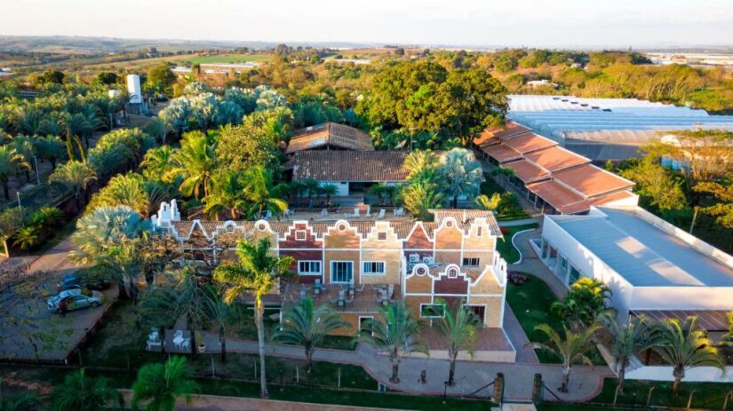 onde ficar em Holambra SP Vista aérea de uma grande propriedade com jardins, árvores tropicais e arquitetura em estilo holandês cercada por vegetação.