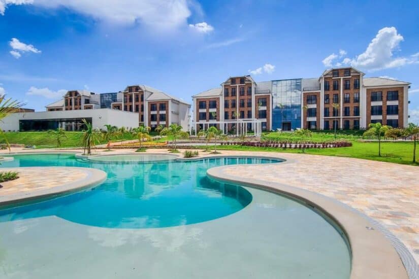hotéis no centro de Holambra Moderno complexo hoteleiro onde ficar em Holambra com fachada de vidro e tijolos, jardins paisagísticos e uma grande piscina externa.
